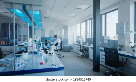 Modern Medical Research Laboratory: Caucasian Male Scientist Wearing Face Mask Working with Pipette, Analysing Biotechnology Sample. Advanced Scientific Lab for Drugs, Microbiology Development - Shutterstock ID 1924512740
