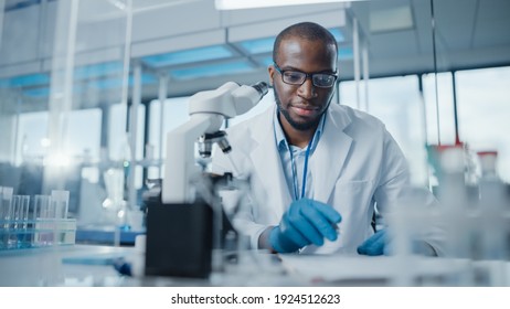 Modern Medical Research Laboratory: Portrait of Male Scientist Using Microscope, Writing Down Analysis Information. Advanced Scientific Lab for Medicine, Biotechnology, Microbiology Development - Shutterstock ID 1924512623