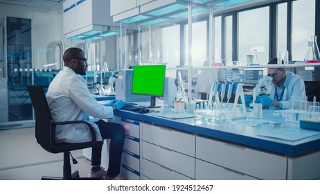 Modern Medical Research Laboratory: Scientist Working On Computer Showing Green Chroma Key Screen. Scientific Lab, Medicine Development Facility With Advanced Equipment, Biotechnology.