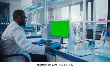 Modern Medical Research Laboratory: Scientist Working On Computer Showing Green Chroma Key Screen. Scientific Lab, Medicine Development Facility With Advanced Equipment, Biotechnology.