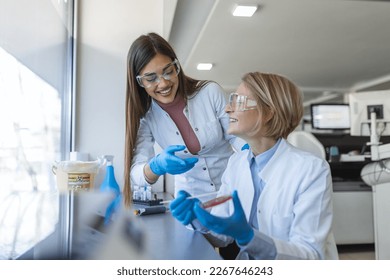 Modern Medical Research Laboratory: Two Scientists Working Together Analysing Chemicals in Laboratory, Discussing Problem. Advanced Scientific Lab for Medicine, Biotechnology, Molecular Biology - Shutterstock ID 2267646243