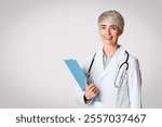 Modern medicine concept. Smiling woman doctor with tablet in hand and stethoscope, isolated on light background, studio shot