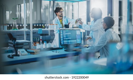 Modern Medicine Research Laboratory: Diverse Team Of Multi-Ethnic Young Scientists Passes Samples In Petri Dish. Advanced Lab With High-Tech Equipment, Microbiology Researchers Design, Develop Drugs