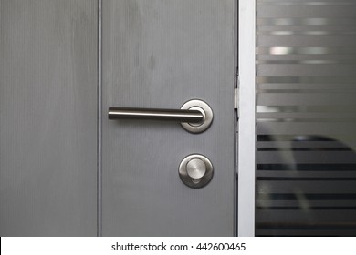 Modern Metal Door Handle Lock Isolated With Black Wooden Door And Frosted Glass Wall In Meeting Room Or Manager Room Or Secretary Room In Regional Head Office