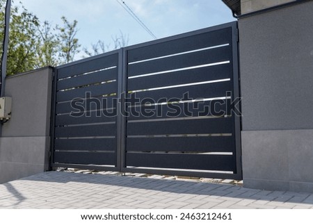 Modern metal fence for fencing the yard area. Horizontal sections of the fence made of metal
