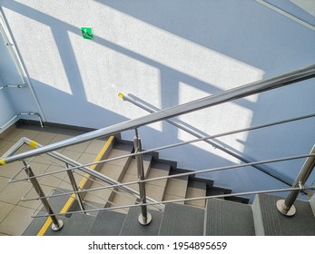 Modern Metal Staircase.Looking Down At A Modern Staircase With White Wall As To Be Found In An Office, Hospital Or An Apartment.sunny Day.yellow Line Helps Visually Impaired The Indoor Stairway