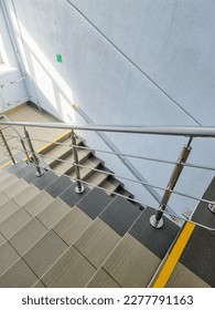 modern metal staircase.Looking down at a modern staircase with white wall as to be found in an office, hospital or an apartment.sunny day.yellow line helps visually impaired the indoor stairway - Shutterstock ID 2277791163
