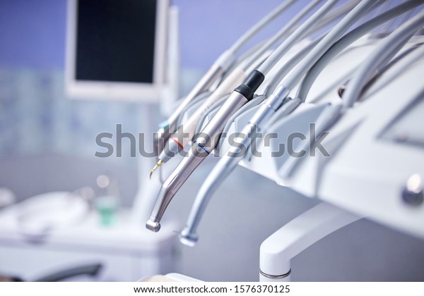 Modern metallic dentist tools and burnishers on\
a dentist chair in Dentist Clinic. Different dental instruments and\
tools in a dentists office.\
