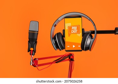 Modern microphone with headphones and mobile phone with with podcast playlist on screen against color background