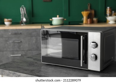 Modern Microwave Oven On Table In Kitchen