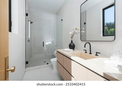 Modern minimalist bathroom with a glass shower, wooden vanity, and black fixtures, featuring a large mirror and a window providing natural light. - Powered by Shutterstock