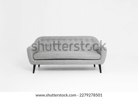 Modern minimalist light gray sofa on white studio background. Sofa decoration with 3-seater cushions.