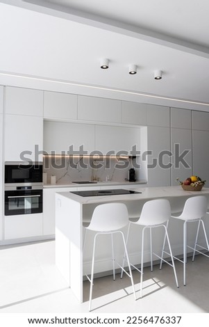 Modern minimalist marble white kitchen, minimalist interior design. Modern furniture with accessories and various utensils, table and chairs in the dining room modern kitchen concept.