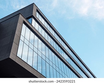 Modern minimalist office building, low angle view looking up, blue sky background - Powered by Shutterstock