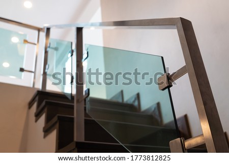 Modern minimalist style stairs with brown wooden and steel handrails in empty modern home building interior.