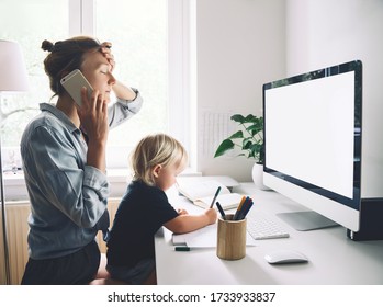 Modern Mom Balances Between Work And Child Home Schooling On Sick Leave Or Quarantine. Mother Works From Home With Kid. Woman Responding On Phone Calls, Working On Computer With A Toddler On Her Lap.