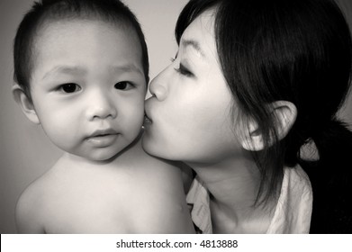 modern mother kissing son - in sepia tone