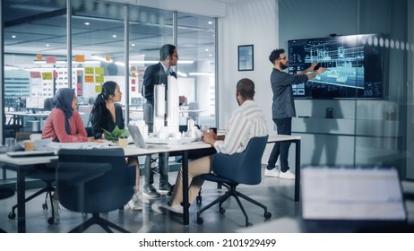 Modern Multi-Ethnic Architectural Agency Office Meeting. Group of Professional Architects, Designers, Developers, Investors Use TV with 3D Building Model to Design Sustainable Housing Project - Powered by Shutterstock