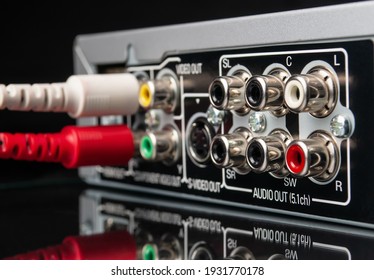 modern multimedia and audio equipment with attached cables on black background close -up