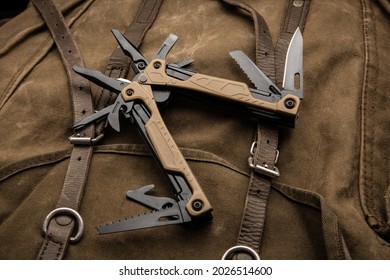 Modern multitool with many tools. A portable multitasking tool on a vintage canvas backpack.