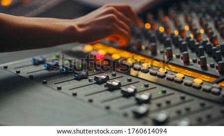 Modern Music Record Studio Control Desk with Automatic Equalizer, Mixer and other Professional Equipment. Switchers, Buttons, Faders, Sliders, Motorized Faders Move, Record, Play Hit Song. Close-up