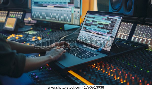 Modern Music Record Studio Control Desk with\
Laptop Screen Showing User Interface of Digital Audio Workstation\
Software. Equalizer, Mixer and Professional Equipment. Faders,\
Sliders. Record.\
Close-up