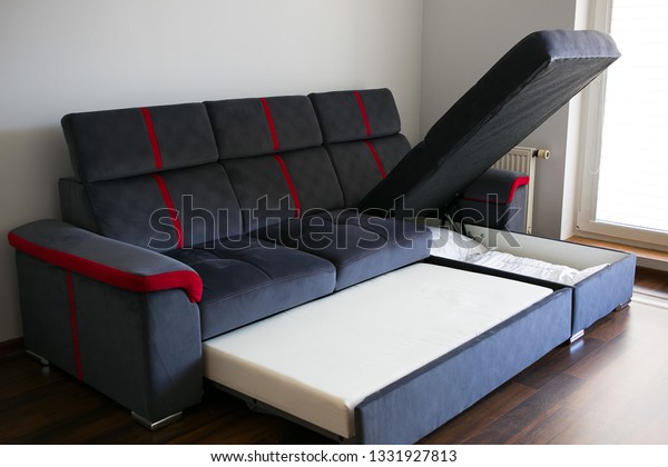 Modern navy blue corner sofa,\
couch with extended mattress for sleeping and storage for\
bedding