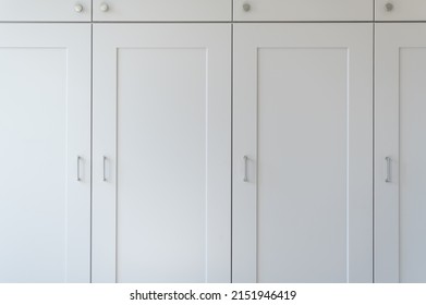 Modern new fitted tall cupboards in kitchen light grey color, interior trendy units. Huge storage inside house, built in wardrobe