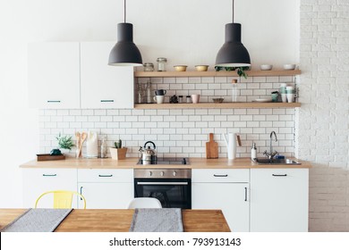 Modern new light interior of kitchen with white furniture and dining table. - Shutterstock ID 793913143