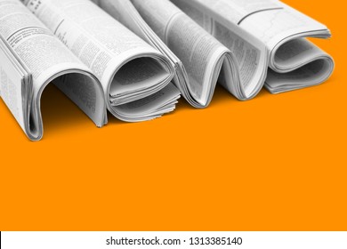 Modern Newspapers Are Folded And Composing Together The Word NEWS, Isolated Over Colored Background. Concept Of Business News, News Media, Print Media And Mass Media At All. Copy Space For Your Text