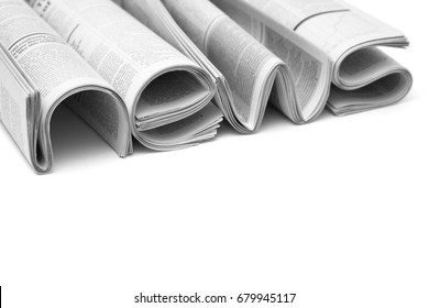 Modern newspapers are folded and composing together the word NEWS, isolated over white background. Concept of business news, news media, print media and mass media at all. Copy space for your text - Shutterstock ID 679945117