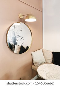 Modern Nordic Scandinavian Interior Design. Bright Open Space With Pale Pink Wall, Round Gold Mirror, Gold Lamp, Marble Table And Comfortable Couch With Soft Curtains.