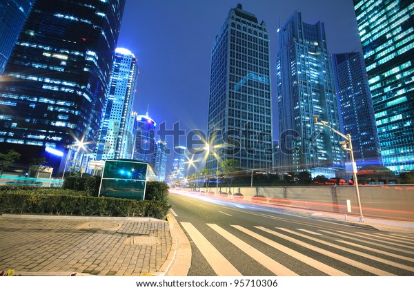 Modern office building background of car night\
with light trails in\
Shanghai