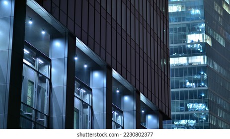 Modern office building in city at the night. View on illuminated offices of a corporate building. Blinking light in window of the multi-storey building of glass and steel. Long exposure at night - Shutterstock ID 2230802377