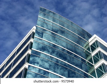 Modern office building with clouds reflected in windows