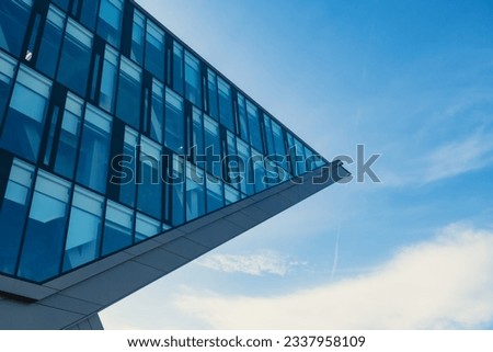 Modern office building exterior with glass facade on clear sky background. Transparent glass wall of office building. Element of facade of modern European building Commercial office buildings