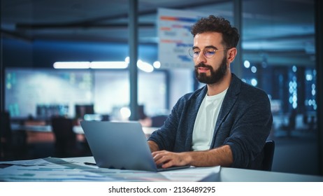 Modern Office Businessman or Manager Working on Computer, Smiling, Looking at Camera. Portrait of Successful IT Software Engineer in Glasses Working on a Laptop at his Desk. - Shutterstock ID 2136489295