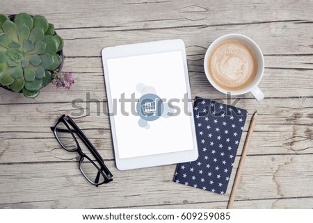 modern office desk with shoppingcart tablet, handy, notepad and cup of coffee