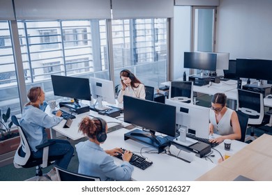 In a modern office, a diverse team collaborates effectively towards shared goals using technology