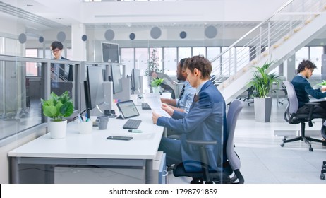 Im modernen Büro: Diverse Team von Managern und Spezialisten arbeiten am Computer, haben Gespräche mit Kollegen und am Telefon. Junge und motivierte Geschäftsleute im Open Office.