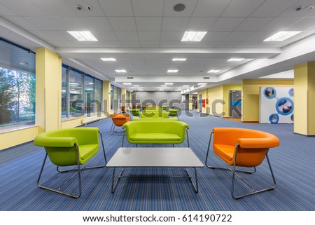 Modern office interior with colorful lounge area, with green and orange furniture