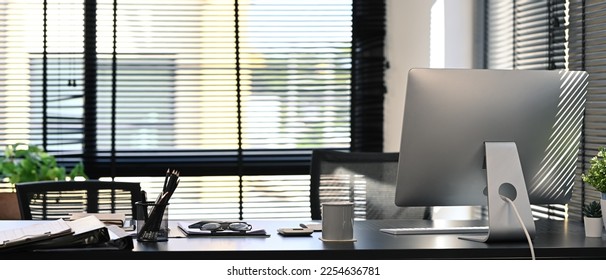 Modern office interior with computer, document supplied and potted plant on blank wooden table - Shutterstock ID 2254636781