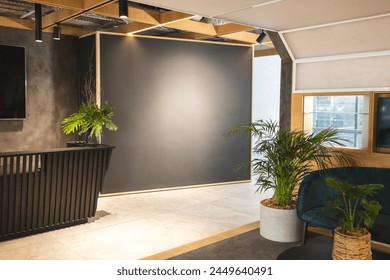 In modern office lounge, green plants adding life to space. Comfortable seating and warm lighting create a welcoming atmosphere, unaltered - Powered by Shutterstock