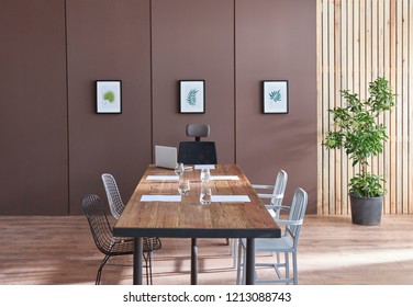 Modern Office Meeting Room Brown Wall And Decorative Pattern Background. Wooden Table Chair And Sofa In The Meeting Room.