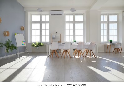 Modern Office Meeting Room With Flip Chart For Corporate Briefing Or Business Negotiations. Bright Interior Of Spacious Office Without People With Large Windows, Table, Chairs And Whiteboard.