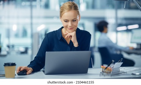 Modern Office: Portrait Of Successful Young Adult Businesswoman Working On A Laptop At His Desk. Smiling Confident Digital Entrepreneur. Beautiful Professional Specialist. Front View Shot