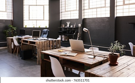Modern office space and tables   chairs  computers   office supplies and no employees 