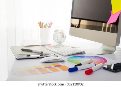 Modern office workplace with digital tablet, notepad, colorful pencils, glasses, in morning - Powered by Shutterstock