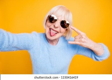 Modern Old Lady Take Selfie Picture Showing Sign Rock And Roll Isolated On Bride Yellow Background