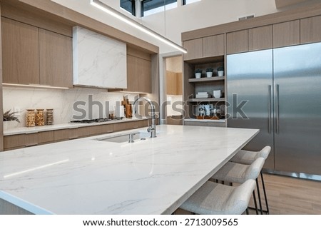 modern open concept kitchen dining interior residential high end house long wooden table stainless steel appliances white countertop sputnik lighting fixture pantry minimalist contemporary design